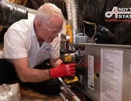 Technician inspecting furnace control wiring with a diagnostic meter